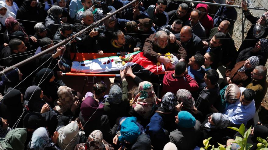 Multitud participa en el funeral de un joven palestino muerto por disparos realizados por dos soldados israelíes en el campo de refugiados de Qalandia, ubicado cerca de al-Quds, 1 de marzo de 2016.