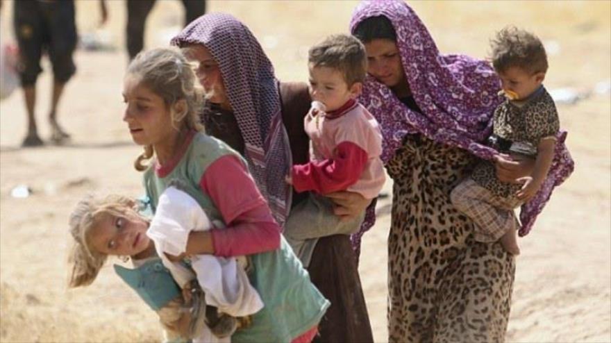 Mujeres izadíes con sus hijos en brazo tratan de huir las violencias del grupo terrorista EIIL (Daesh, en árabe).