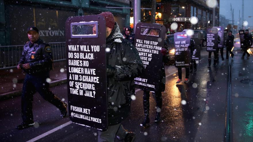 Los manifestantes estadounidenses protestan contra la violencia policial fuera del histórico Teatro Fox en Detroit antes del debate presidencial republicano. 3 de marzo de 2016