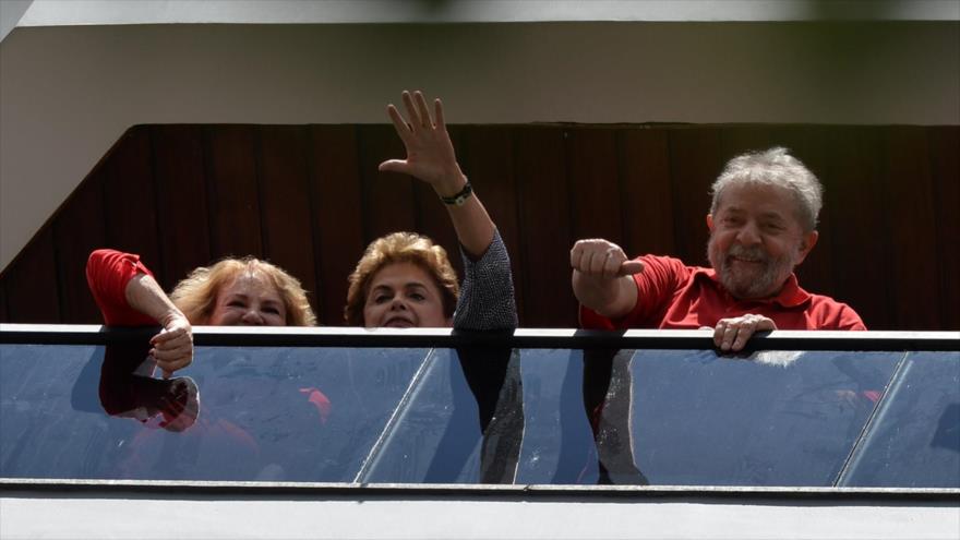 La presidenta de Brasil, Dilma Rousseff (centro), y su antecesor Luiz Inacio Lula da Silva, saludan a sus seguidores congregados delante de la casa del exmandatario en Sao Bernardo do Campo, cerca de Sao Paulo, 5 de marzo de 2016.