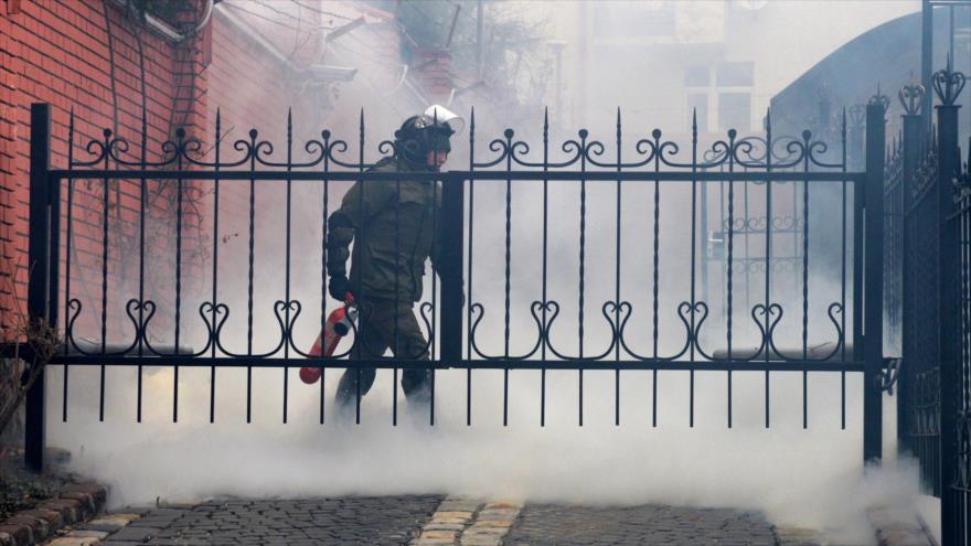 Un miembro de las fuerzas de seguridad se apaga una bomba de humo en el consulado de Rusia en Lvov (este de Ucrania), 9 de marzo de 2016.