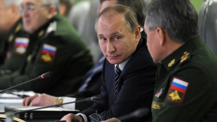 El presidente ruso, Vladimir Putin, junto al ministro de Defensa de Rusia, Serguei Shoigu (dcha.), durante su encuentro con autoridades militares y líderes de la industria defensiva del país, 11 de marzo de 2016.