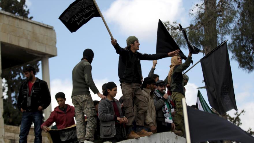 Integrantes del grupo terrorista Frente Al-Nusra, la filial de Al-Qaeda en Siria, ondean banderas de la formación terrorista en la localidad de Marat Numan, en la norteña provincia de Idlib, 11 de marzo de 2016.