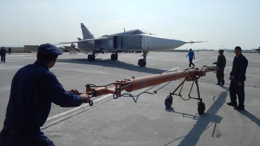 Militares rusos preparan la retirada a Rusia de un avión en la base aérea de Hmeimim.
