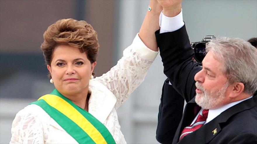 La presidenta de Brail, Dilma Rousseff (izda.), alza la mano de su antecesor Luiz Inácio Lula da Silva.