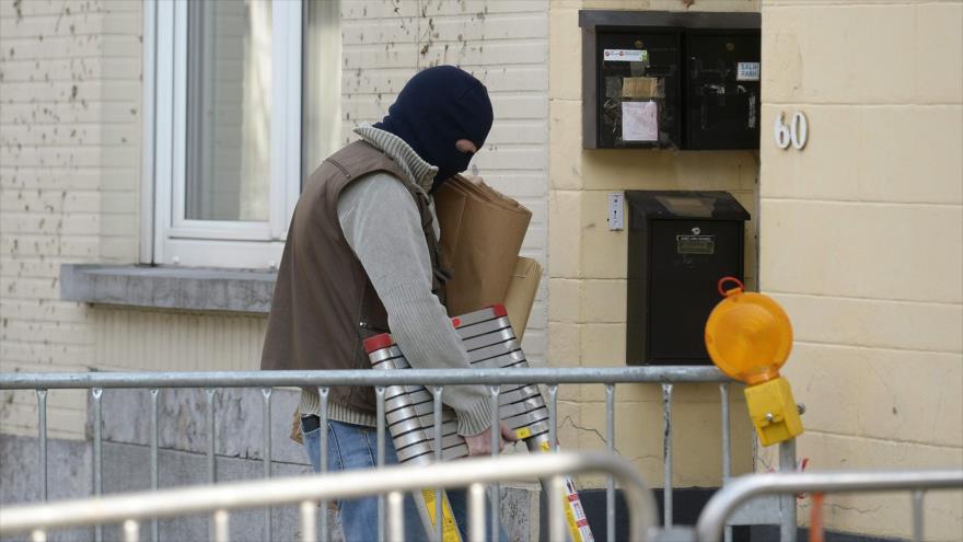 Un agente policial bélga, delante de una vivienda de la zona popular de la comuna de Forest, en la capital belga, donde se registró tiroteos entre la Policía y sospechosos armados. 16 de marzo de 2016