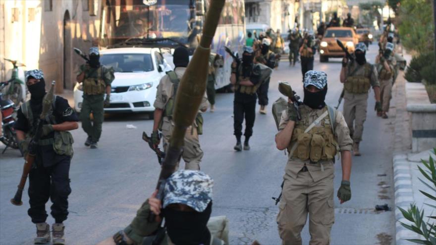 Integrantes del grupo terrorista EIIL (Daesh, en árabe), en un desfile en las calles de Alepo (Siria).