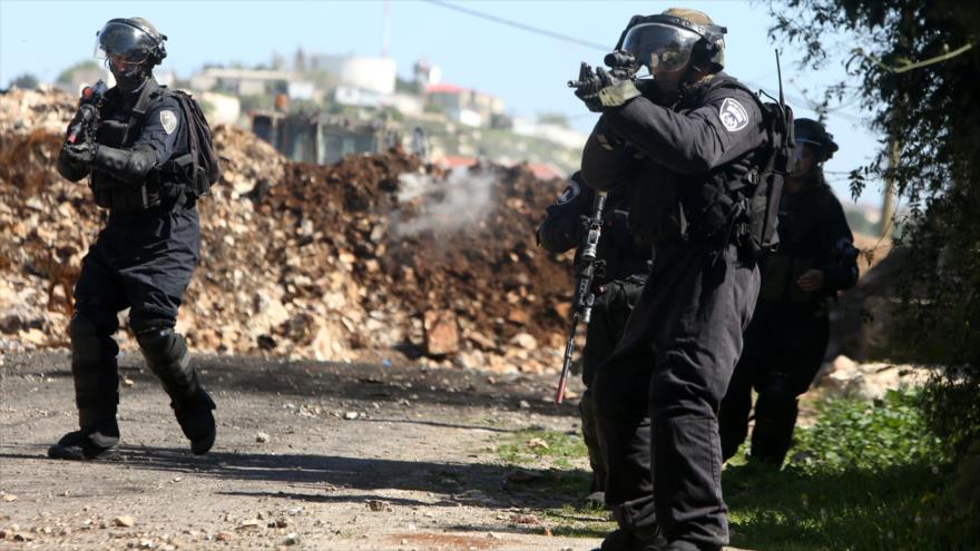 Soldados israelíes apuntan sus armas contra palestinos en una protesta en la ciudad cisjordana de Nablus.