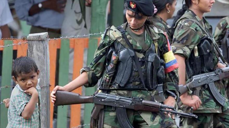 Un niño colombiano junto a miembros de las Fuerzas Armadas Revolucionarias de Colombia (FARC).