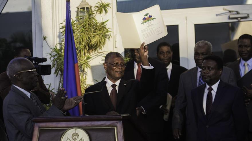 El presidente interino de Haití, Jocelerme Privert, muestra al público el documento de nombramiento oficial del nuevo primer ministro, Jean Fritz-Alphonse, en el Palacio Nacional en Puerto Príncipe, 26 de febrero 2016.