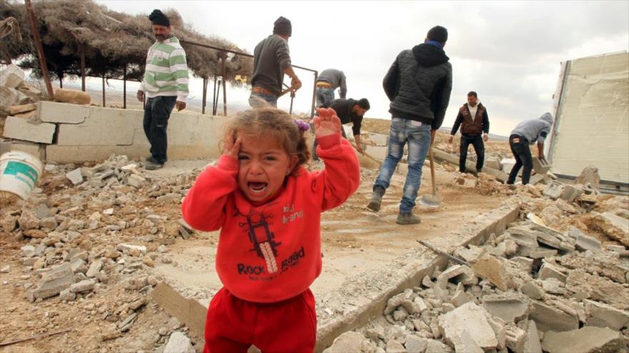 Un niño palestino llorando entre los escombros de las viviendas destruidas por bombardeos del régimen de Israel.