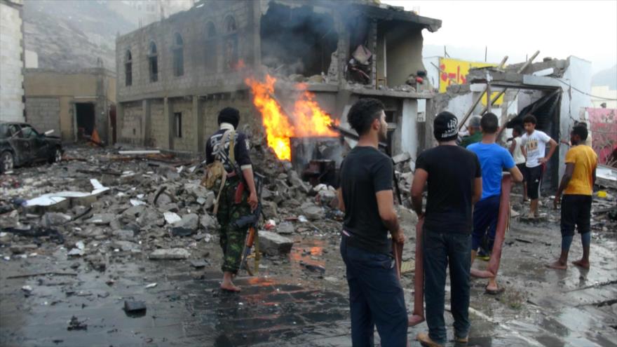 Los ciudadanos yemeníes intentan apagar el fuego causado por el estallido de un coche bomba en Adén, sur de Yemen.