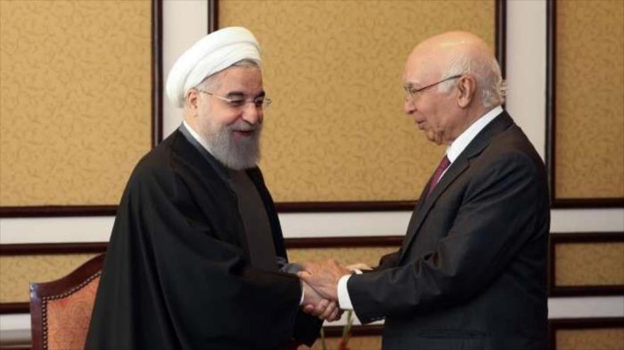 El presidente iraní, Hasan Rohani (izda.), saluda a Sartaj Aziz, asesor de Seguridad Nacional y Política Exterior del primer ministro paquistaní. 26 de marzo de 2016