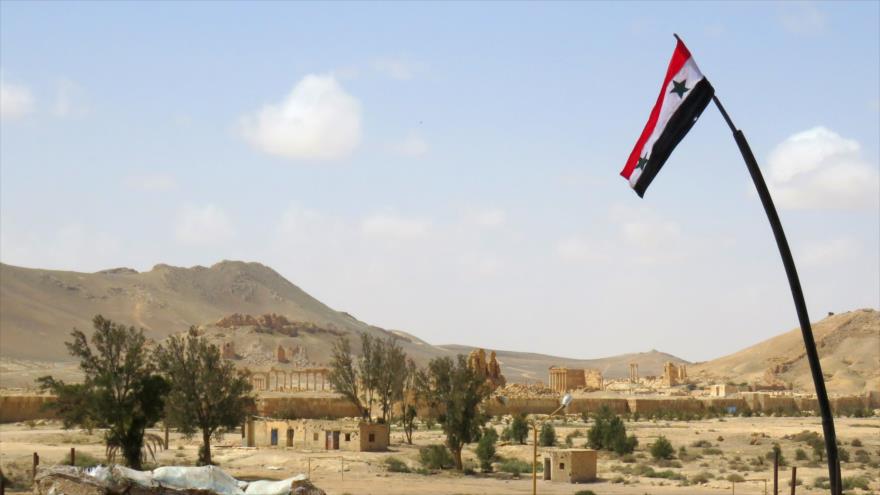 Fuerzas sirias han izado la bandera de su país en la histórica ciudad de Palmira (centro) tras su liberación total de manos de los terroristas de Daesh, 27 de marzo de 2016. 