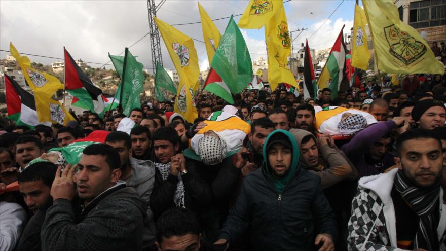Enlutados palestinos participan en el funeral de tres palestinos asesinados por soldados israelíes en el sur de la ocupada Cisjordania, 9 de enero de 2016.