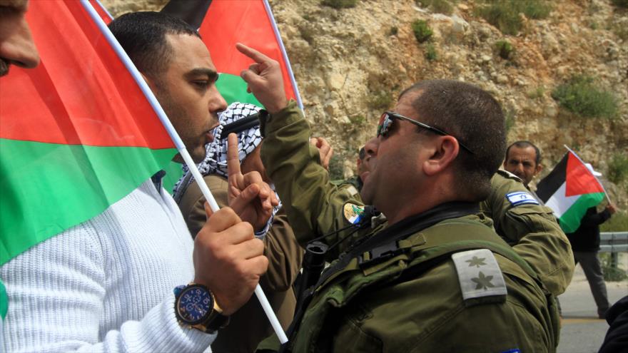 Un miembro de las fuerzas de seguridad israelíes (dcha.) y un manifestante palestino durante los enfrentamientos surgidos tras una manifestación con motivo del Día de la Tierra, en el pueblo cisjordano de Burqa, al oeste de Nablus, 30 de marzo de 2016. 