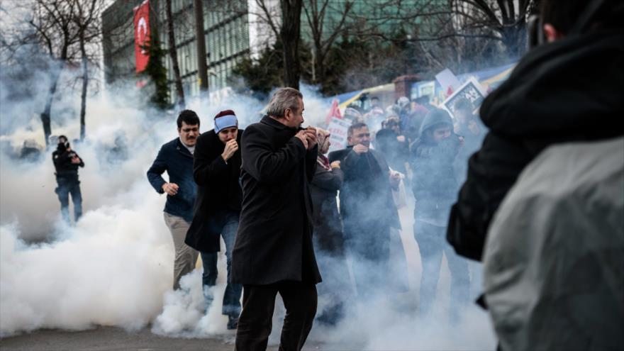 Manifestantes turcos ante la sede del diario Zaman en la ciudad de Estambul son atacados con gases lacrimógenos, 5 de marzo de 2016.