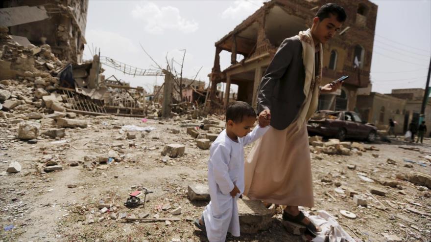 Un hombre yemení y un niño caminan sobre los escombros de los edificios destruidos en un bombardeo saudí en Saná, la capital. 