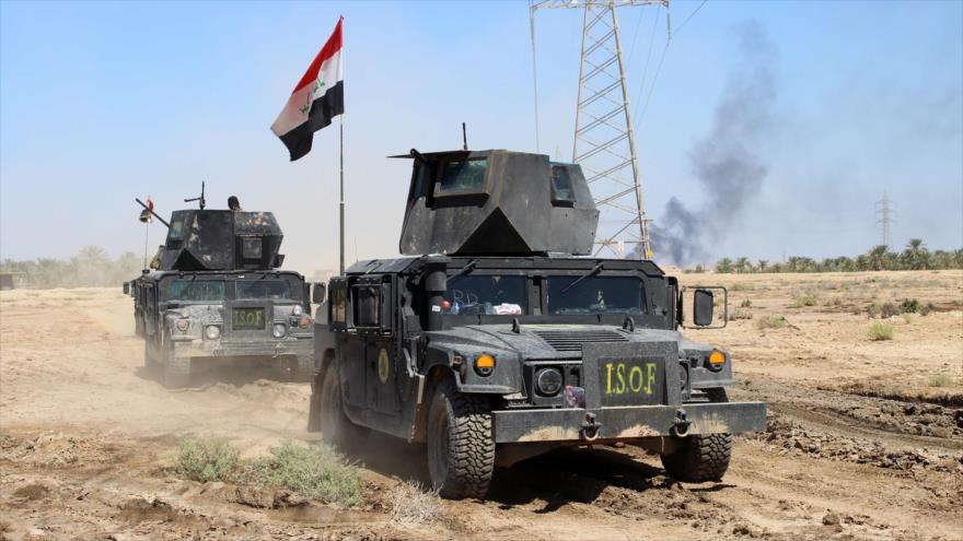 Fuerzas iraquíes conducen sus vehículos blindados tras liberar una área de los terroristas del grupo takfirí EIIL (Daesh, en árabe), cerca de la ciudad de Hit, en la provincia occidental de Al-Anbar.