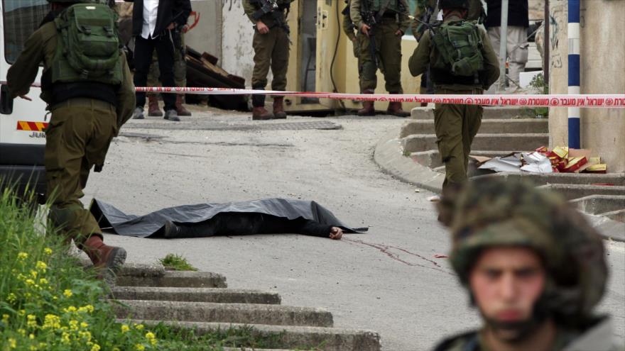 Cuerpo sin vida de un joven palestino abatido a tiros por soldados israelíes en la localidad cisjordana de Al-Jalil.