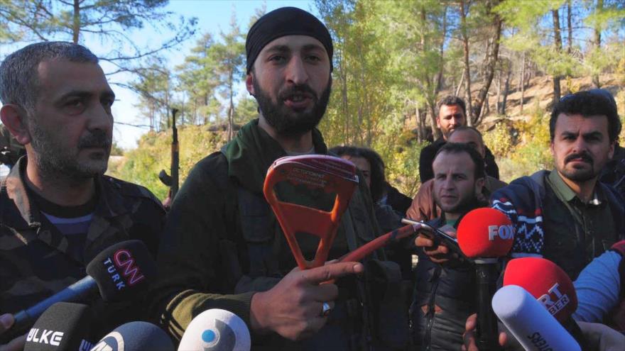 Alpaslan Celik muestra los equipamientos de paracaidismo del piloto del avión militar ruso Sujoi Su-24, derribado por los cazas turcos.
