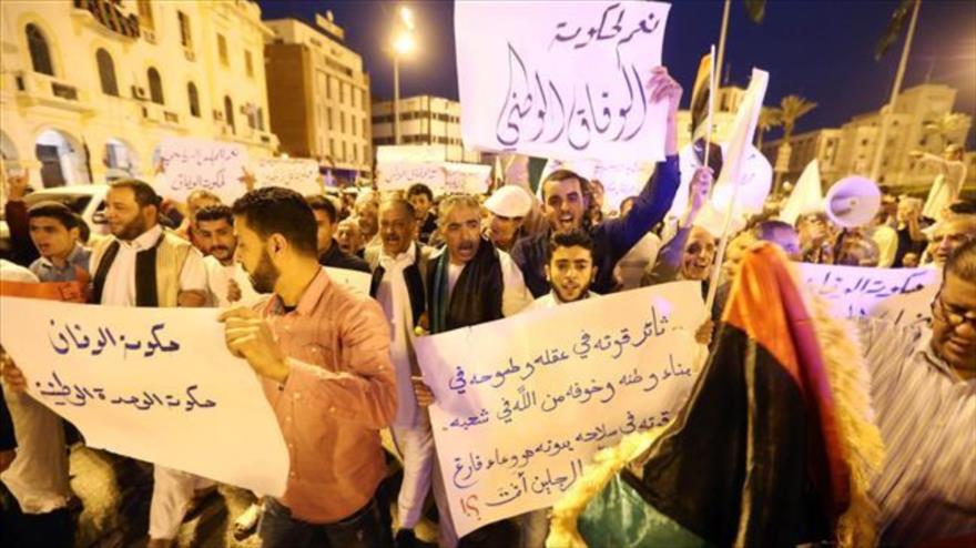Manifestantes que apoyan al gobierno de unidad nacional sostienen pancartas y gritan consignas durante una manifestación en la capital libia, Trípoli, 1 de abril de 2016. 