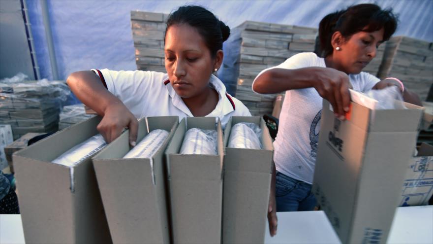 Dos trabajadoras de la Oficina Nacional de Procesos Electorales (ONPE) reúnen material electoral en Lima, capital de Perú, 31 de marzo de 2016.
