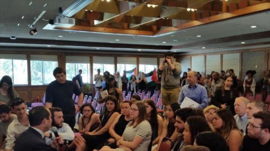 Los activistas, portando las banderas de Palestina, entran en la sala de conferencia de la Universidad de California e intentan interrumpir la intervención de Nir Barkat, alcalde de Al-Quds (Jerusalén), 6 de abril de 2016.