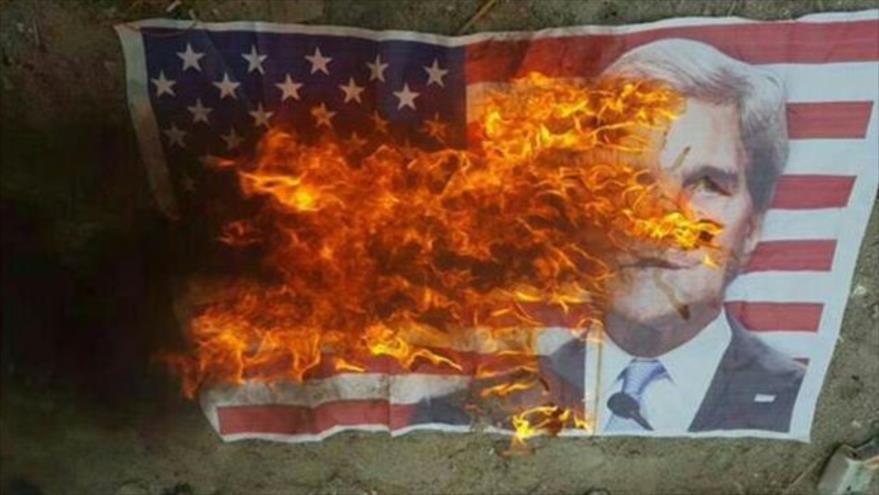 Bareiníes queman una bandera de EE.UU. con la imagen de John Kerry durante su manifestación, 7 de abril de 2016.