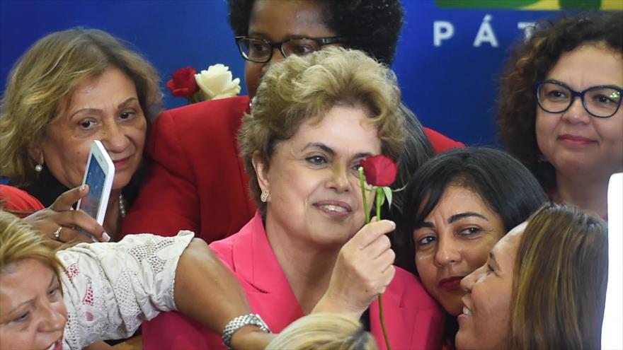 La presidenta de Brasil, Dilma Rousseff, recibe una rosa roja durante el evento en Defensa de la Democracia, palacio de Planalto, Brasilia, 7 de abril de 2016.