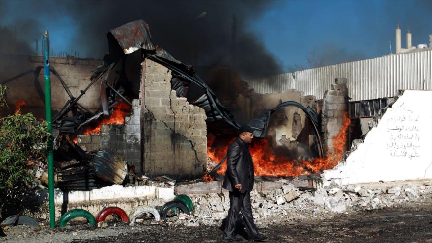 Un hombre yemení pasa ante las ruinas de un edificio destruido por la aviación de Arabia Saudí en Saná (capital de Yemen).