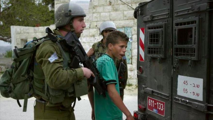 Fuerzas de seguridad israelíes detienen a un niño palestino.