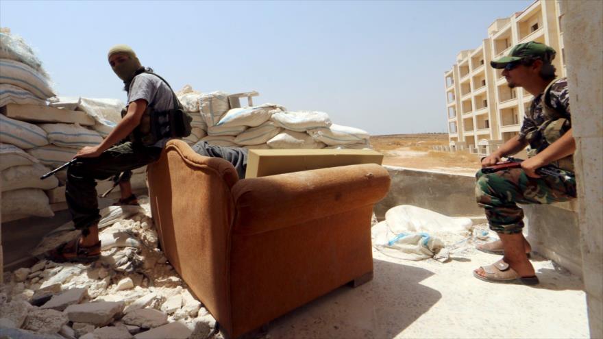 Miembros del Frente Al-Nusra descansan en una trinchera de sacos de arena en el barrio de Sheij Maqsud de la ciudad noroccidental de Alepo.