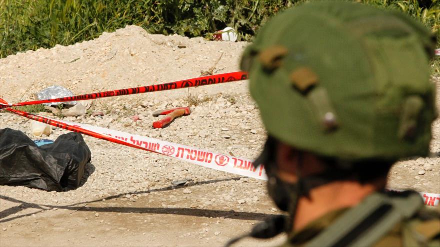 Soldado israelí observa el cuerpo de un palestino muerto en un tiroteo de militares del régimen de Tel Aviv en la ciudad cisjordana de Al-Jalil (Hebrón).