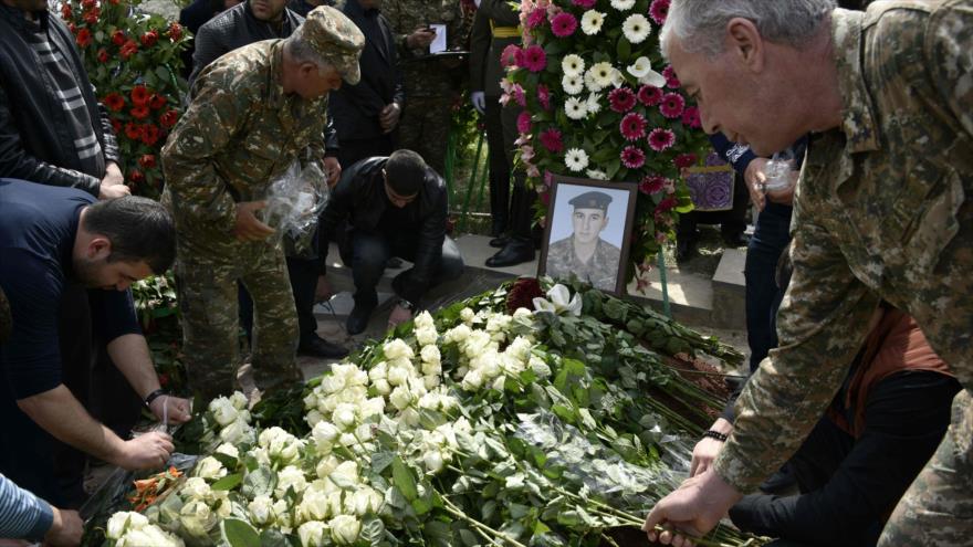 Un hombre deposita flores en la tumba de un oficial armenio, que murio en el conflicto de Nagorno Karabaj.