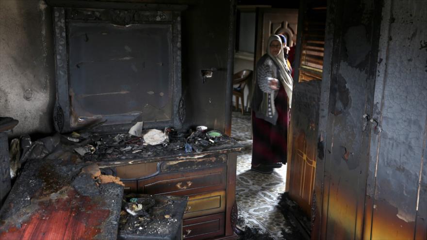 Palestinos observan la casa incendiada del único testigo del caso de la quema de otra casa provocado por extremistas judíos el año pasado, en la ocupada localidad cisjordana de Kafr Duma, el 21 de marzo de 2016.