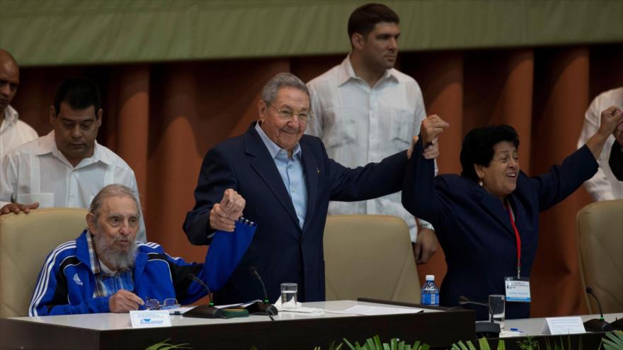 El presidente de Cuba, Raúl Castro (centro) y su hermano el expresidente Fidel Castro (izda.) levantando sus manos durante la ceremonia de clausura del VII Congreso del Partido Comunista de Cuba (PCC) en el Palacio de Convenciones de La Habana, 19 de abril de 2016.