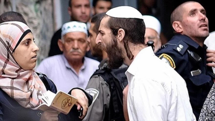 Un judío, acompañado por militares israelíes, grita a una mujer palestina en Al-Aqsa.
