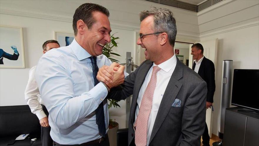 El candidato presidencial del Partido de la Libertad de Austria, Norbert Hofer (dcha.), estrecha sonriente la mano del líder de la formación, Heinz-Christian Strache, tras conocerse el resultado preliminar de su triunfo electoral, 24 de abril de 2016.