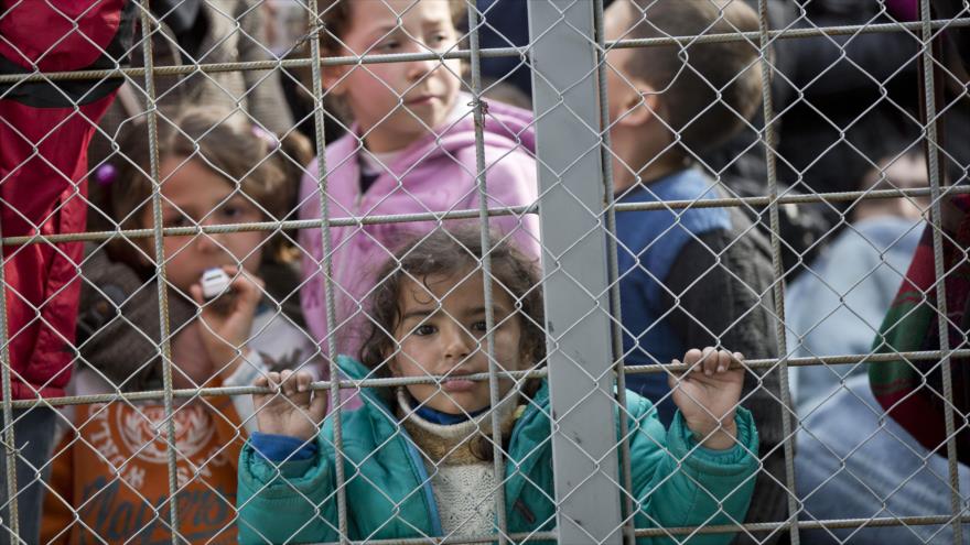 Una niña refugiada espera en la parte griega de la frontera para entrar en Macedonia, cerca de la ciudad meridional macedonia de Gevgelija, 3 de marzo de 2016.