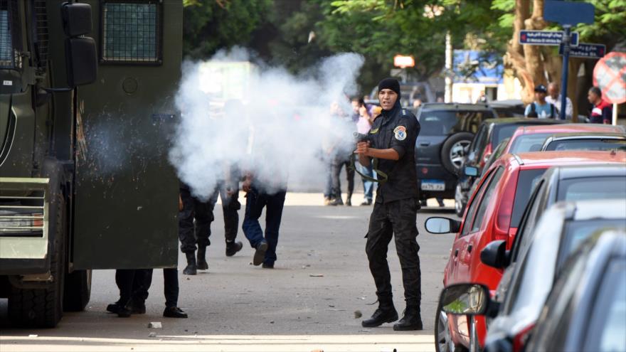 Un agente de la policía antidisturbios egipcio dispara gas lacrimógeno contra los manifestantes pacíficos en El Cairo (capital).