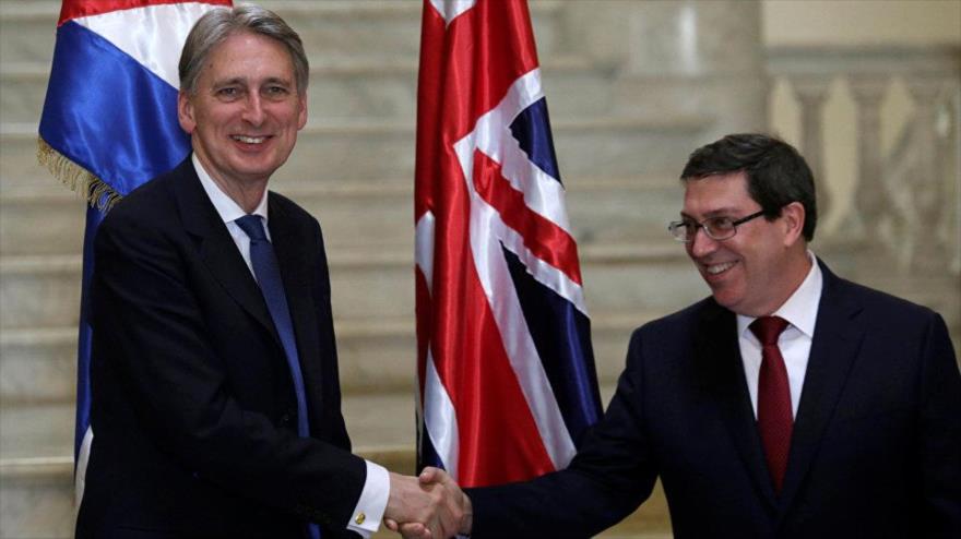 El canciller británico, Philip Hammond (izda.), y su par cubano, Bruno Rodríguez Parrilla, estrechan las manos tras reunirse en la Habana, la capital de Cuba, 28 de abril de 2016.