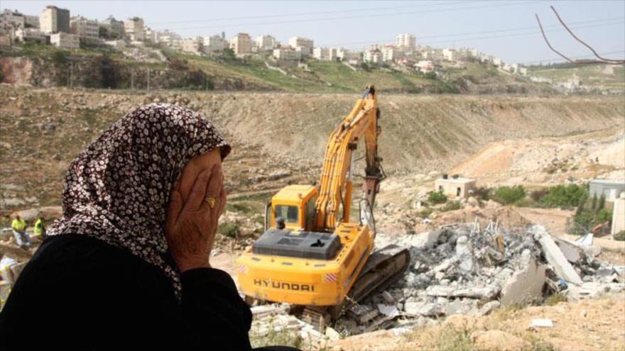 Fuerzas israelíes derriban una casa palestina en Cisjordania frente a sus dueños.