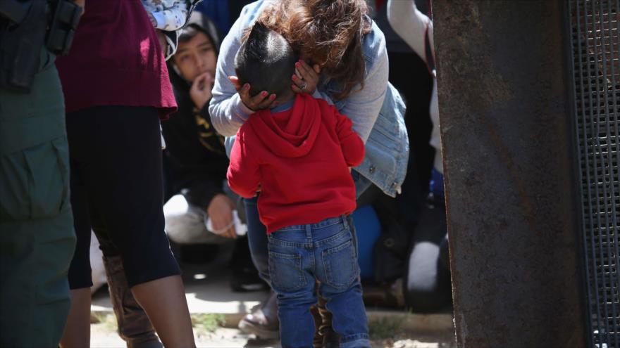 Una familia mexicana se abraza con cariño ante los guardias de la frontera México-EE.UU.