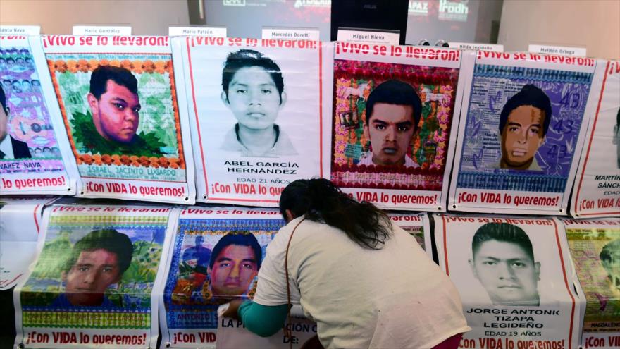 Una familiar de uno de los 43 estudiantes mexicanos desaparecidos prepara carteles de los normalistas con sus fotos, 9 de febrero de 2016.