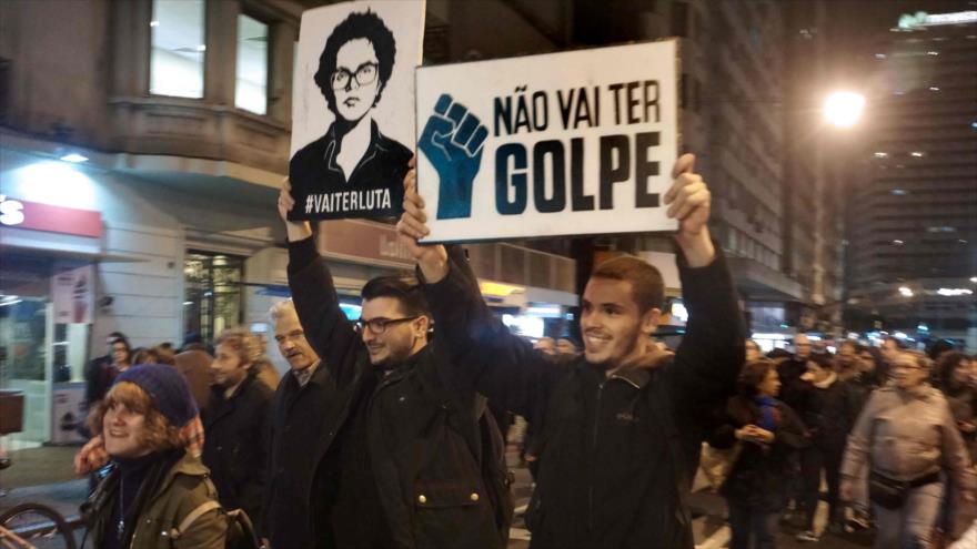 Manifestantes sostienen carteles que decían "No habrá golpe de Estado" y "Va a ver una pelea" durante una marcha en contra de la apertura de un juicio político a la presidente brasileña Dilma Rousseff, 10 de mayo de 2016. 