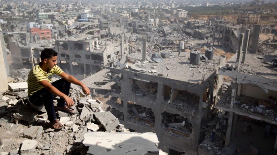 Un palestino mira las casas destruidas por la ofensiva del régimen israelí contra la Franja de Gaza, 6 de agosto 2014.