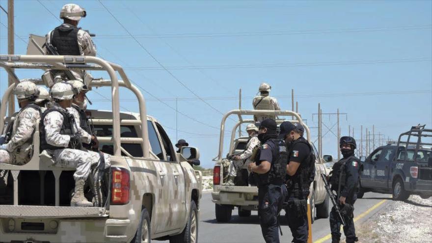 Policías y fuerzas del Ejército méxicanos en un puesto de control cerca de un centro penitenciario en la Ciudad Juarez, 7 de mayo de 2016. 