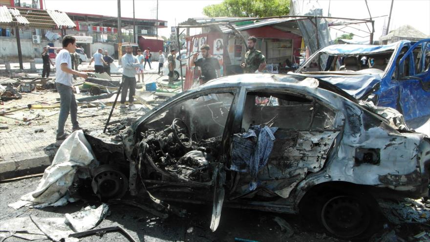 Sirios reunidos en la zona donde varios atentados con coche bomba dejaron decenas de heridos en la ciudad de Jableh, en la provincia occidental de Latakia, 23 de mayo de 2016.