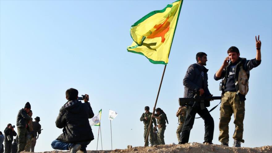 Combatientes de las Unidades de Protección del Pueblo Kurdo (YPG, en kurdo), el brazo armado del PYD, ondean su bandera.